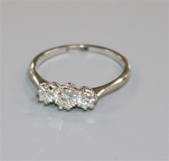 An 18ct gold and platinum, three stone diamond ring, size O.